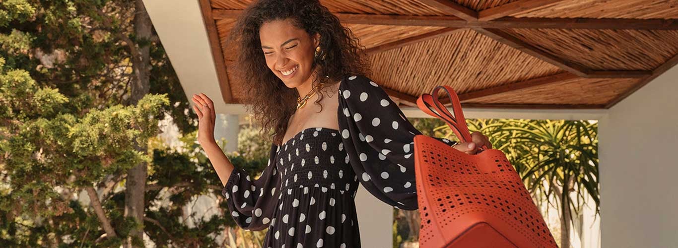 Polka dot dress and orange bag for autumn campaign. 